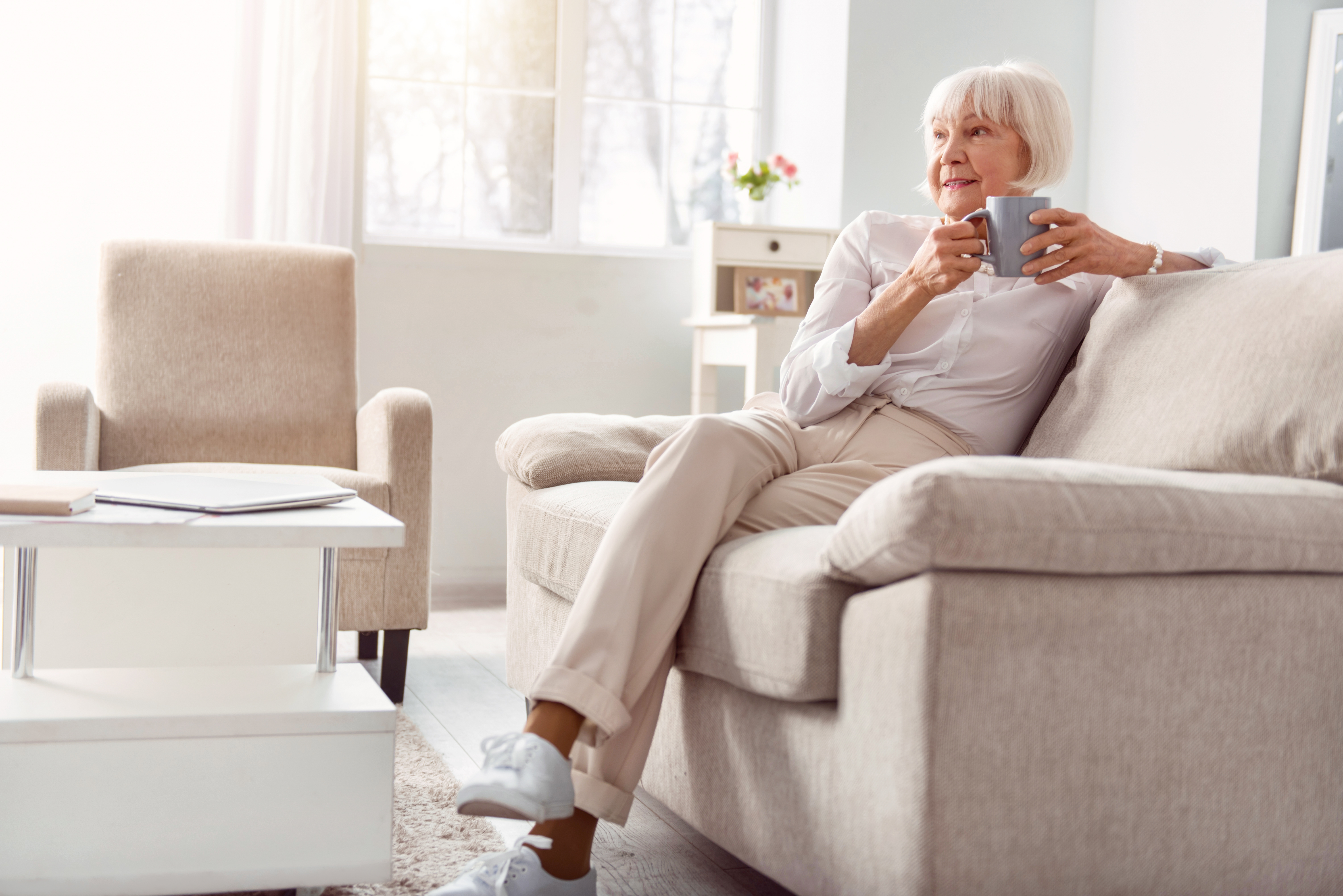 Женщина пожилых лет в каком то спальном. Пожилая женщина сидит на диване. Интерьер для пожилой женщины. Пенсионеры на диване. Бабушка на диване.